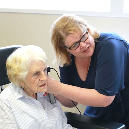 Audiologist Shannon M. Christsen examining a patient with an otoscope with a digital attachment