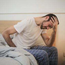 Man sitting on edge of bed